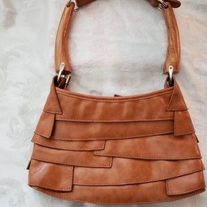 Unique and chic tan purse with wooden handles.